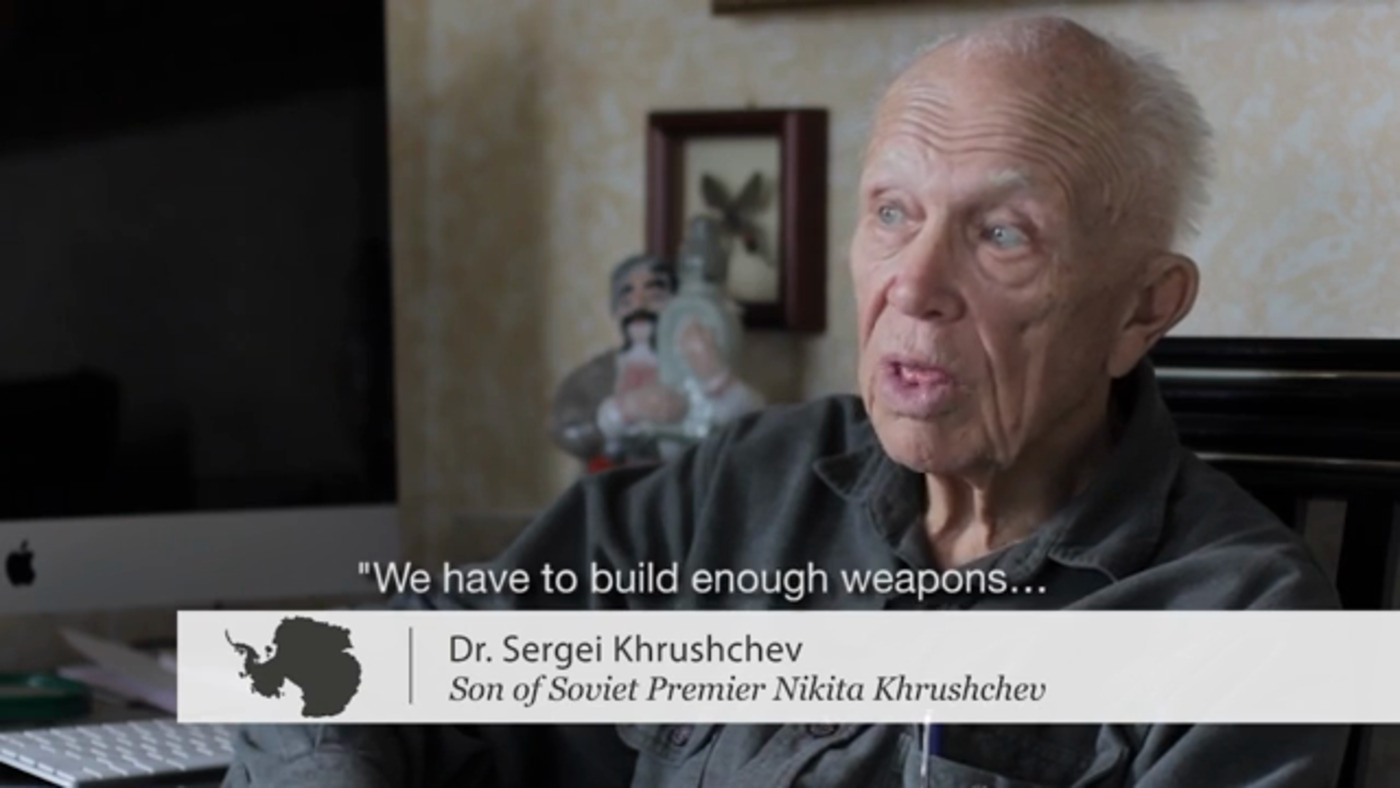 Dr. Sergei Khrushchev mid-interview, captioned “We have to build enough weapons…”, with the lower-third Son of Soviet Premier Nikita Khrushchev
