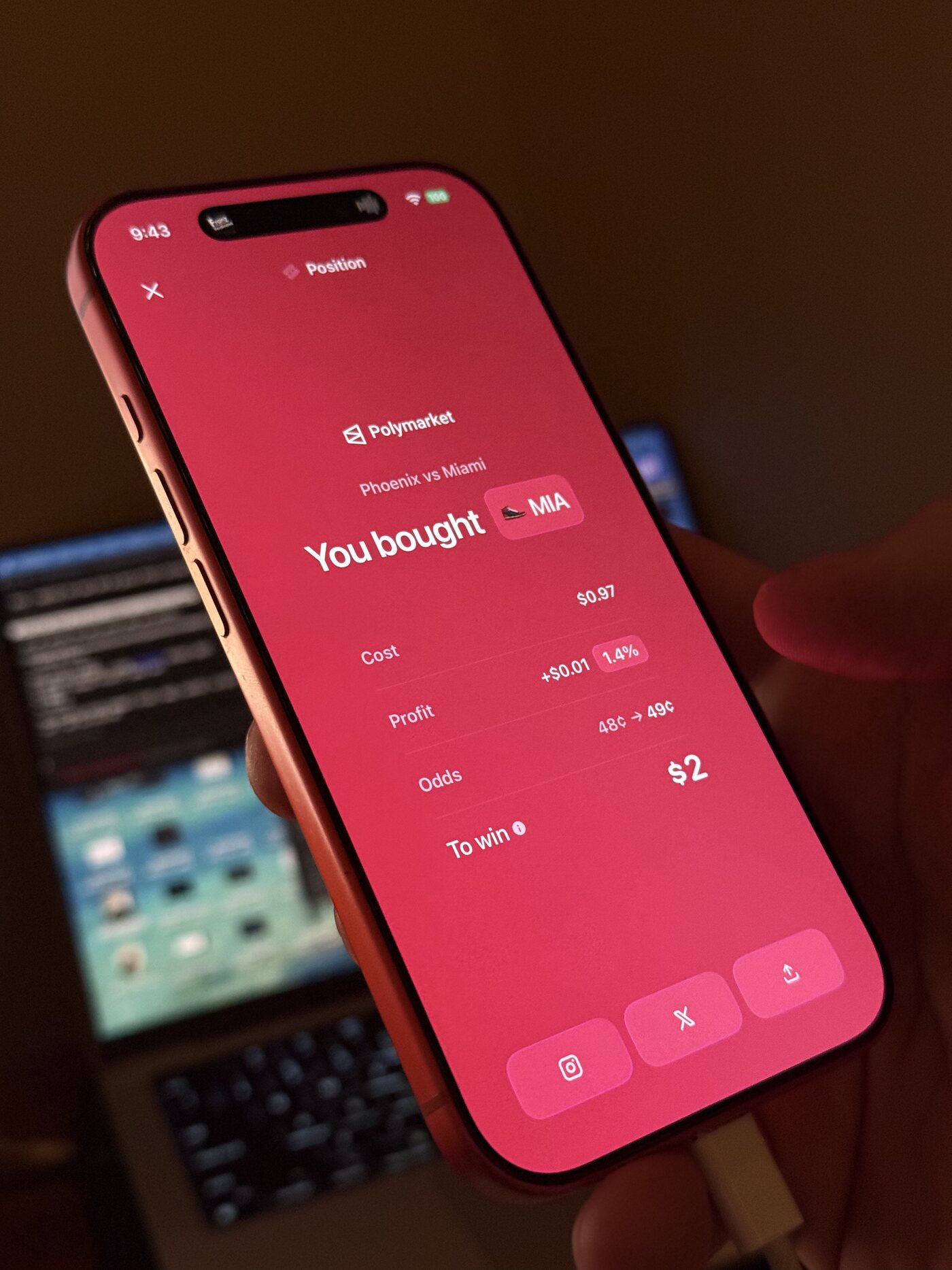 An iPhone held in hand showing a red Polymarket share card: You bought MIA, $2